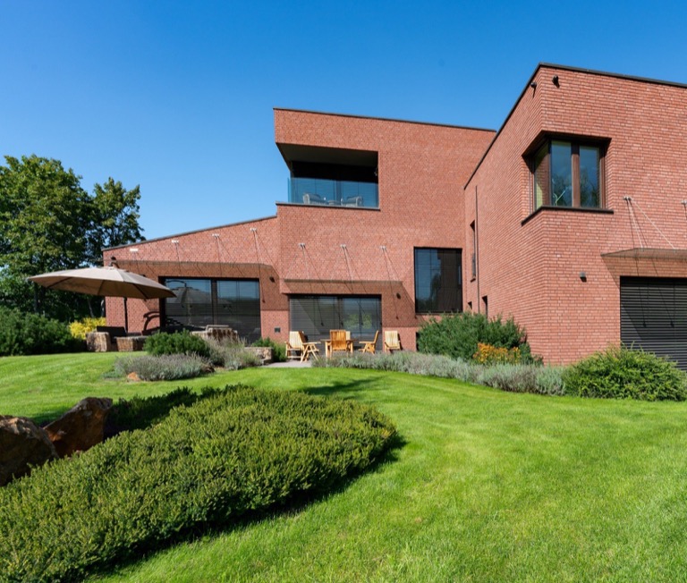 Sfeerbeeld (Unsplash): hedendaagse woning in baksteen