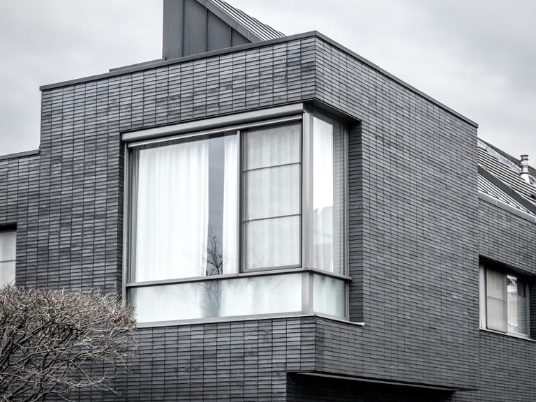 Sfeerbeeld (Unsplash): hedendaagse woning met donkere leien gevel
